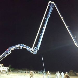 Concrete pumper boom extended at night