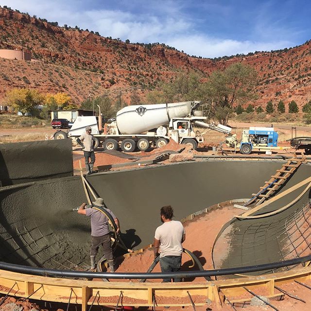 Workers blasting shotcrete on curved walls for skate park